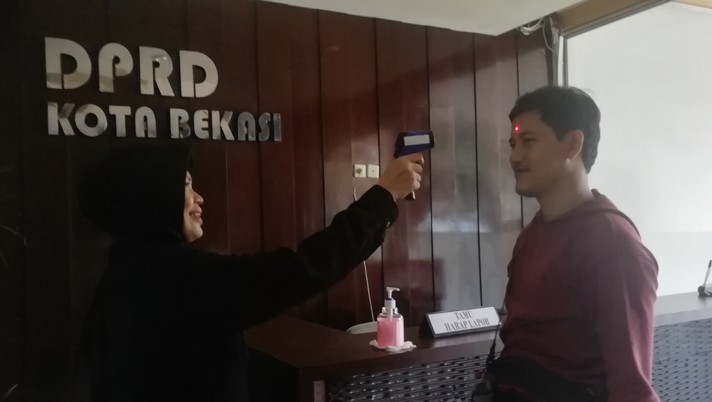 Salah satu Pengunjung DPRD Kota Bekasi melakukan Pengecekan Suhu Tubuh, (17/3).
