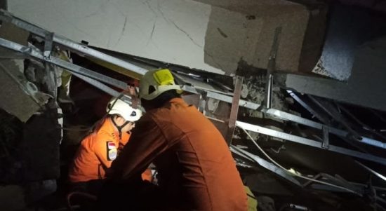 Foto Caption : Petugas Basarnas sedang mengevakuasi korban yang terjebak reruntuhan sebagai dampak gempa di Mamuju, Sulawesi Barat, Jumat, (15/1).