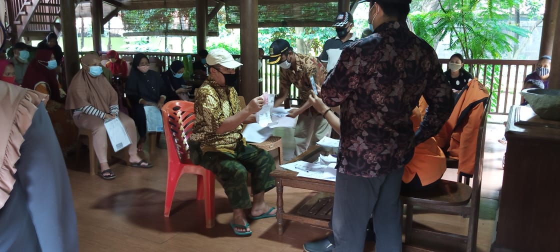 Foto Caption : Warga Terima BST (Bantuan Sosial Tunai) dengan melampirkan persyaratan (Foto Copy KTP dan KK) kepada Petugas, Selasa, (19/1).